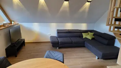 a living room with a couch and a television at Domačija Loncnar in Bohinj