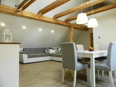 a living room with a couch and a table and chairs at Domačija Loncnar in Bohinj