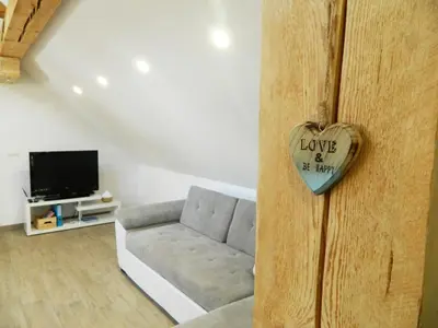 a living room with a couch and a heart on the door at Domačija Loncnar in Bohinj