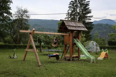 a girl is playing on a playground at Domačija Loncnar in Bohinj