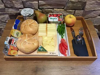 a tray of food with cheese bread and apples on a table at Apartments Avio in Zgornji Brnjik