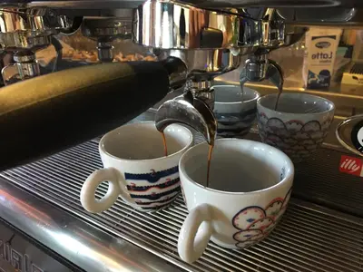 two coffee cups with coffee being being poured into them at Apartments Avio in Zgornji Brnjik