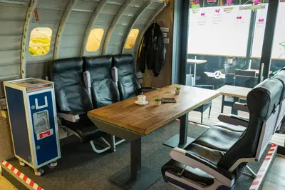 a table and leather chairs in an airplane at Apartments Avio in Zgornji Brnjik