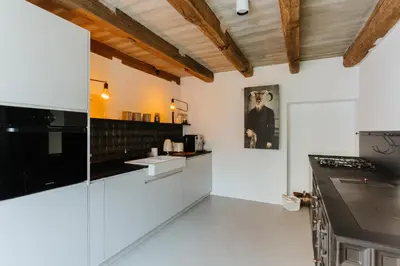 a kitchen with white cabinets and black appliances at Villa LISA - VILLA WITH SWIMMING POOL AND HUGE GARDEN in Mozirje
