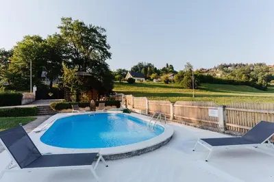 a swimming pool with two lounge chairs and a swimming poolvisor at Villa LISA - VILLA WITH SWIMMING POOL AND HUGE GARDEN in Mozirje