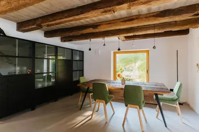 a dining room with a wooden table and green chairs at Villa LISA - VILLA WITH SWIMMING POOL AND HUGE GARDEN in Mozirje