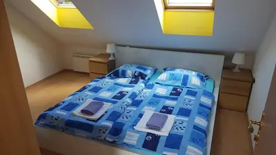 a bed with a blue comforter and pillows at Apartments Lake Bohinj Medja in Bohinj