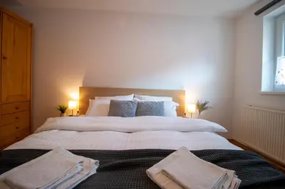 a bedroom with a large bed with two towels on it at Apartments Pod Bregom in Kranjska Gora