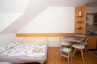a small bedroom with a bed and a table at Apartment Tinka Kranjska Gora in Kranjska Gora