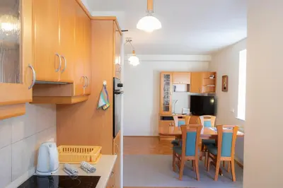 a kitchen and a living room with a table and chairs at Apartment Tinka Kranjska Gora in Kranjska Gora