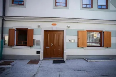 a building with a brown door and two windows at Apartment Tinka Kranjska Gora in Kranjska Gora