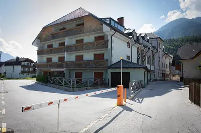 a large building with a parking lot in front of it at Apartment Tinka Kranjska Gora in Kranjska Gora