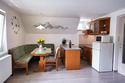 a small kitchen with a table and a refrigerator at Apartma SIMONA in Bohinj