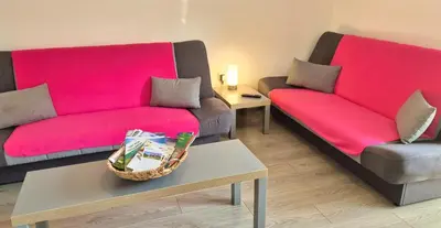 a living room with two couches and a pink couch at Apartma SIMONA in Bohinj