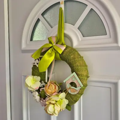 a wreath hanging on a door with flowers at Apartma SIMONA in Bohinj