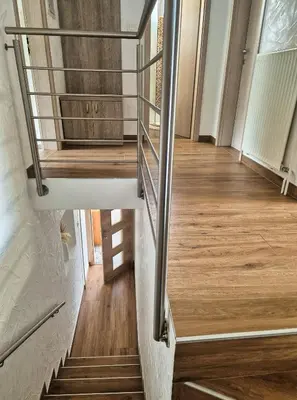 a staircase in a house with wood floors and a stair railing at Apartma SIMONA in Bohinj