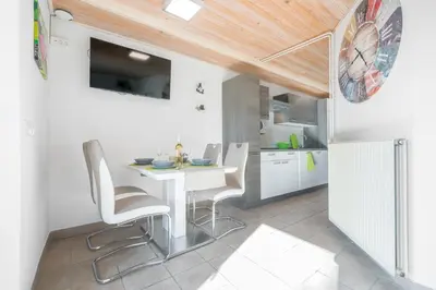 a kitchen and dining room with a white table and chairs at Apartment - Speleo Camp in Logatec