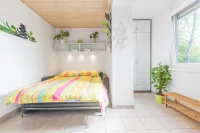 a bedroom with a bed with a colorful blanket at Apartment - Speleo Camp in Logatec