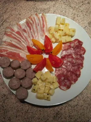 a plate of food with different types of meats and cheese at Tourist Farm Strle With Great Local Food in Cerknica