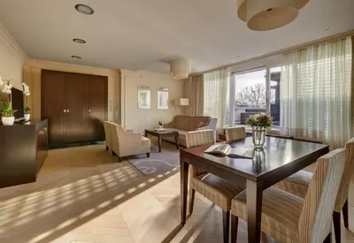 a living room with a table and a dining room at Hotel Aleksander Medical & SPA in Rogaška Slatina
