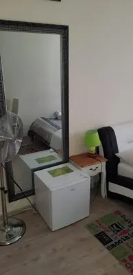 a bedroom with a mirror and a bed and a chair at ELG Rooms in Postojna