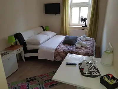 a small bedroom with a bed and a table at ELG Rooms in Postojna