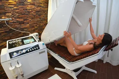 a woman laying on a bed next to a machine at ApartHotel Vila Minka in Ljubljana