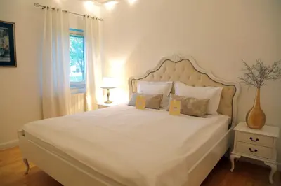 a bedroom with a large white bed with two yellow signs on it at ApartHotel Vila Minka in Ljubljana