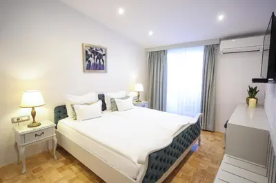 a bedroom with a large bed and a window at ApartHotel Vila Minka in Ljubljana