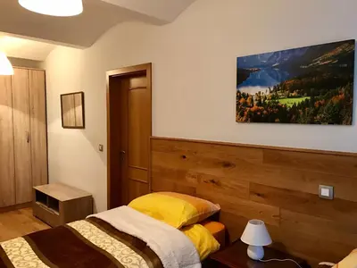 a bedroom with two beds and a painting on the wall at Bled Home in Bled