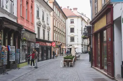 a street in a city with people walking down the street at Sweet 16 Studio in Ljubljana