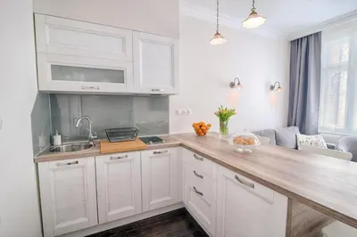 a kitchen with white cabinets and a wooden counter top at Sweet 16 Studio in Ljubljana