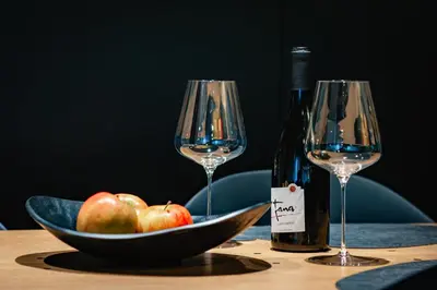 a bowl of apples and two wine glasses on a table at Fana Estate in Dobrovo