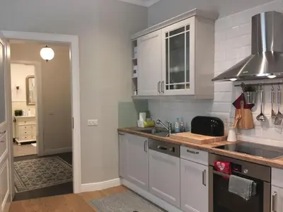 a kitchen with white cabinets and a sink at FORUM Apartment I and II in Ljubljana