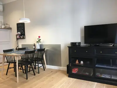 a dining room with a table and a black dresser at FORUM Apartment I and II in Ljubljana