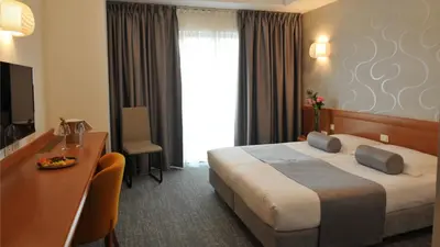 a hotel room with a bed and a desk at Hotel Venko in Dobrovo