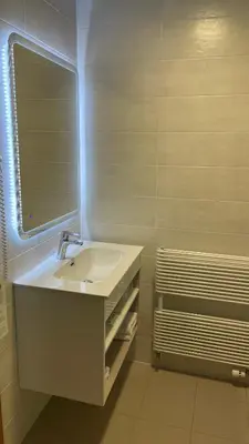 a white bathroom with a sink and a mirror at Hotel Venko in Dobrovo