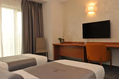 a hotel room with a desk and a television at Hotel Venko in Dobrovo