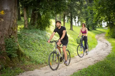 a man and woman riding bikes down a dirt road at Hotel Zagreb - Health & Beauty in Rogaška Slatina