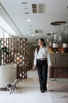 a woman walking a small dog on a leash at Hotel Zagreb - Health & Beauty in Rogaška Slatina