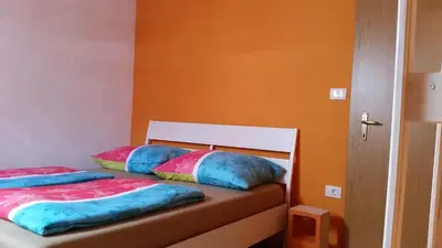 a bedroom with two beds with colorful pillows at Thirsty River Rooms in Bovec