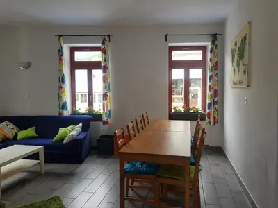 a living room with a table and a blue couch at Thirsty River Rooms in Bovec