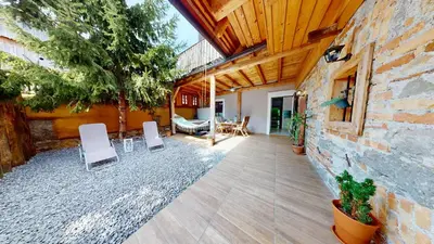 a patio with white chairs and a brick wall at Resort Hisa Ida - Apartments with Hot Tub and Sauna in Ivančna Gorica
