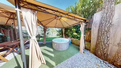 an umbrella over a hot tub in a backyard at Resort Hisa Ida - Apartments with Hot Tub and Sauna in Ivančna Gorica