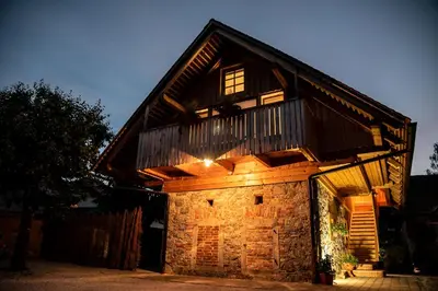 a large wooden building with a balcony on top at Resort Hisa Ida - Apartments with Hot Tub and Sauna in Ivančna Gorica