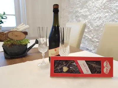 a bottle of wine and two glasses on a table at Romantic Apartments Sweet Baci in Maribor