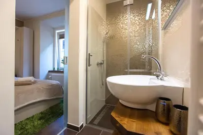 a bathroom with a white sink and a shower at Romantic Apartments Sweet Baci in Maribor