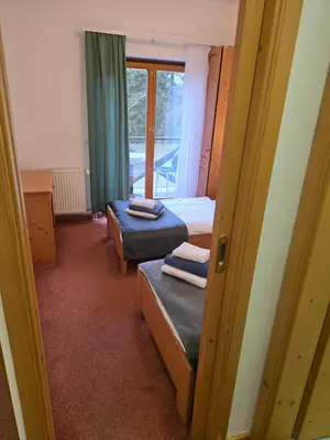 a small room with two beds and a window at Hotel Rakov Skocjan in Cerknica