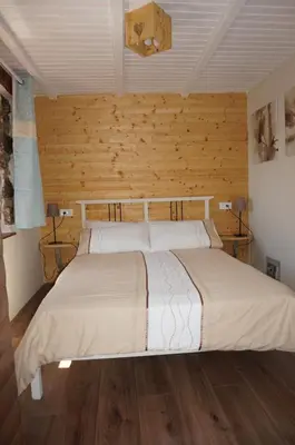 a bedroom with a large bed with wooden walls at Valley View Apartment in Kambreško