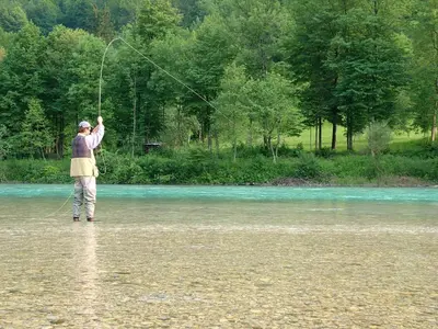 a man is standing in a river holding a kite at Valley View Apartment in Kambreško